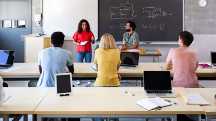 Siswa mendengarkan teman sekelas perempuan memberikan presentasi lisan