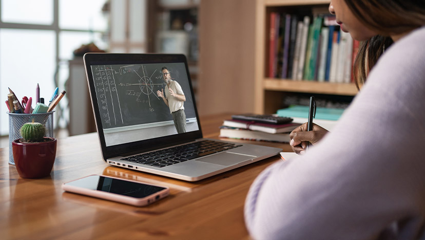 Siswa remaja menonton video di laptop belajar dengan kursus kuliah online dari rumah
